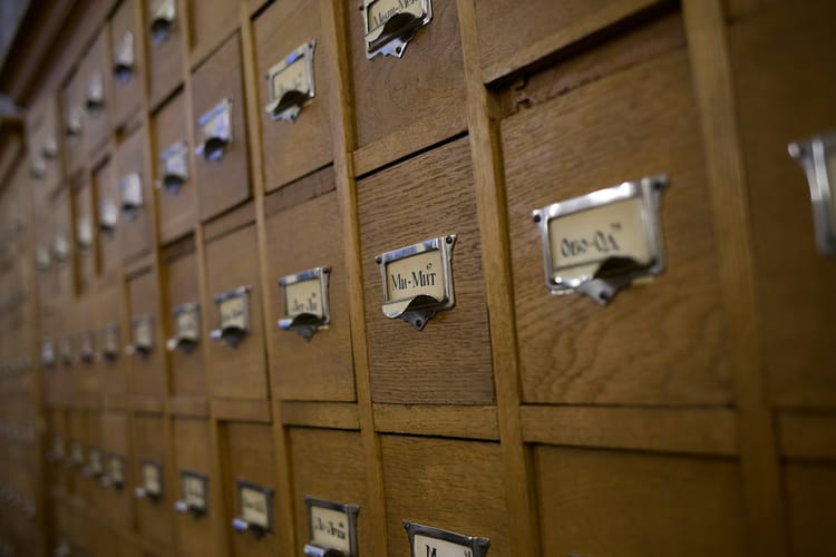 Wooden card catalog drawers with metal labels — a memory system you can touch