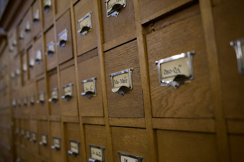 Wooden card catalog drawers with metal labels — a memory system you can touch
